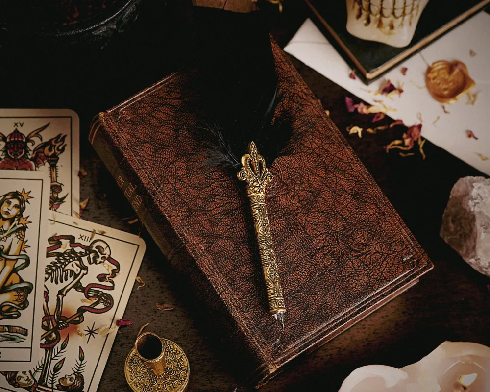 Symbolic Tarot imagery beside a journal and quill for recording associations